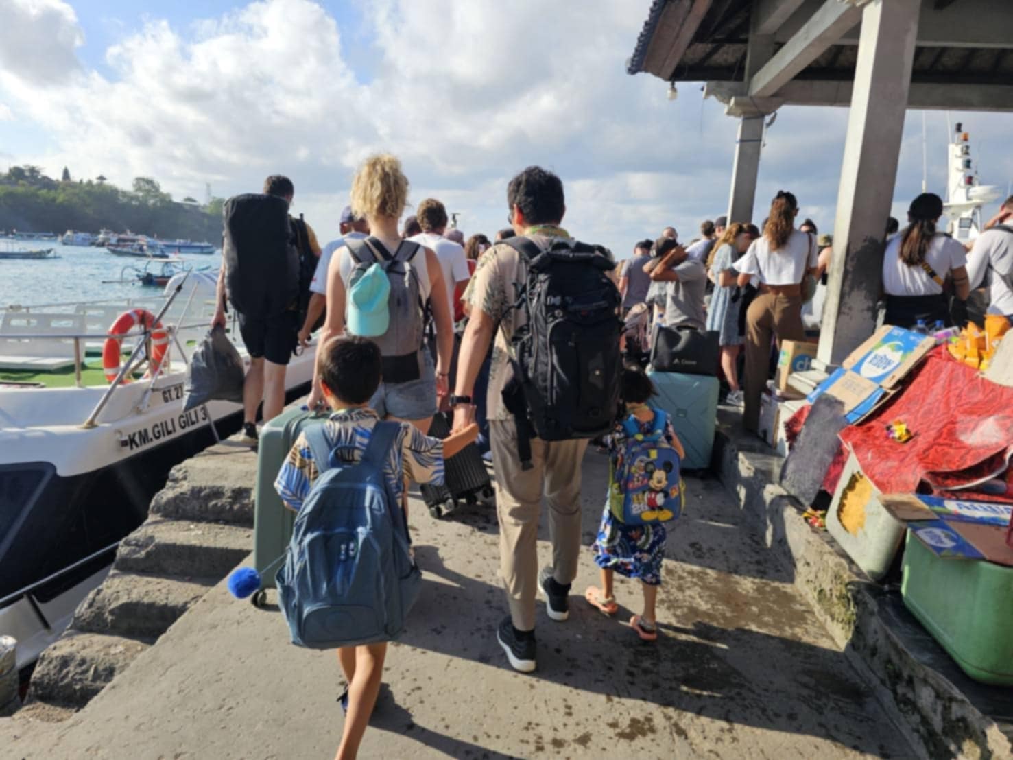 在前往 Padangbai 登船的過程中，我建議可以提前一天住在附近，因為無論是從南部還是從烏布前往 Padangbai，車況都相當難以掌握，容易出現延誤。這個碼頭的環境非常混亂，人潮洶湧，讓人有些無所適從。  在碼頭附近，會有許多當地人主動幫忙提行李，但這些人有時會強取行李並要求小費。我在這裡也遇到了類似的情況，行李一瞬間就被人拿走，出於無奈只好給小費以免引起不必要的麻煩。每個人通常會要求 5萬印尼盾 的小費，我則選擇只給了 1萬印尼盾，不想被拉扯太久。其實他們大多數時候是急著去幫其他旅客搬行李，所以不會爭執太久，這樣也算是避免了一些困擾